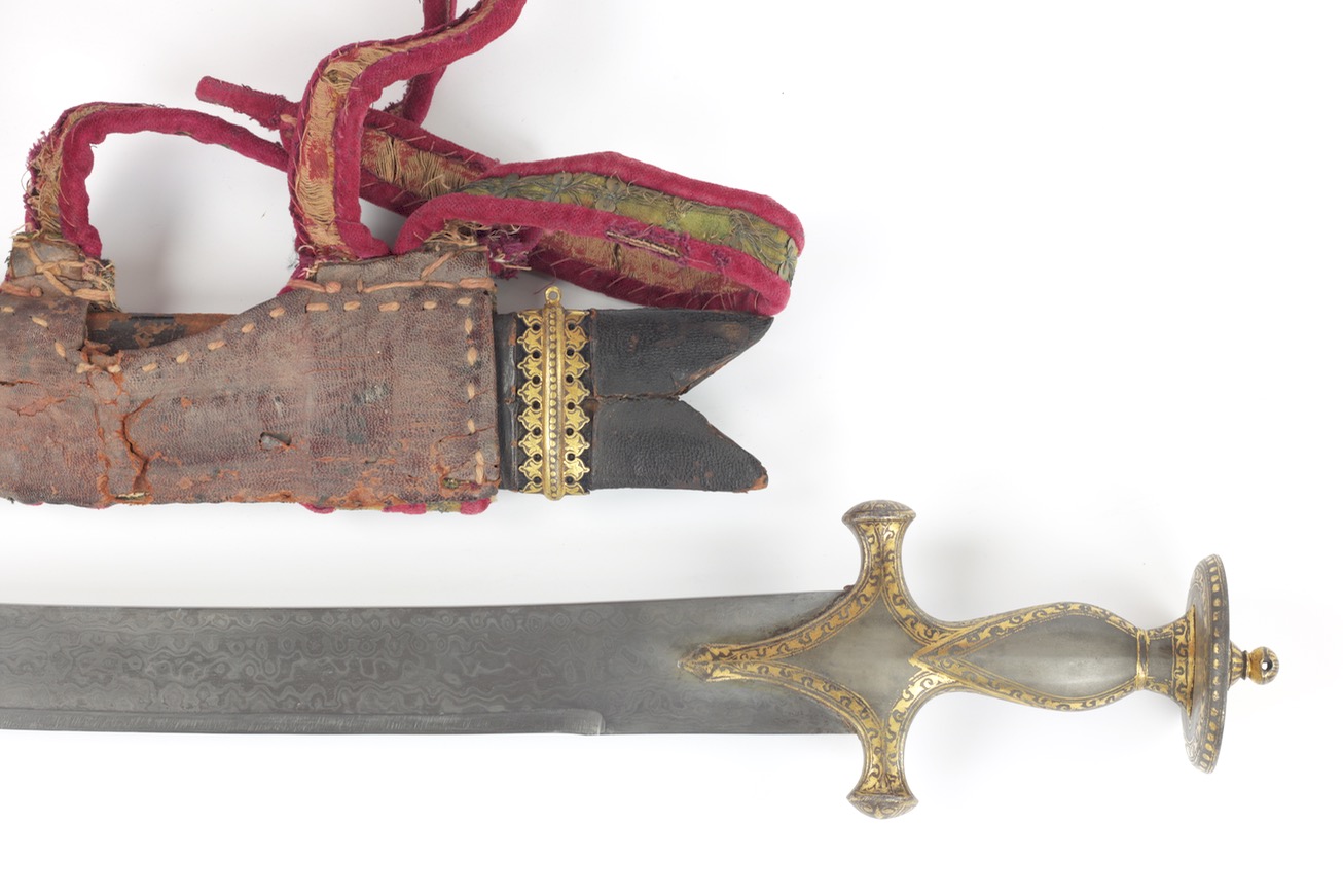 Antique Indian talwar. A heavy Indian talwar with wootz hilt elaborately decorated with gold koftgari. Its blade of mechanical damascus steel.