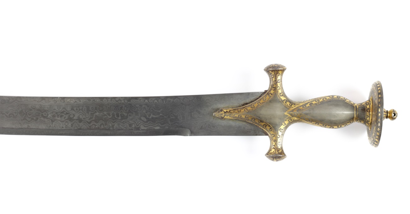 Antique Indian talwar. A heavy Indian talwar with wootz hilt elaborately decorated with gold koftgari. Its blade of mechanical damascus steel.